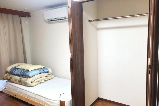 リゾートバイトの個室寮の室内。マットレスとエアコン、クローゼットが備え付けられ、シンプルで過ごしやすい寮の部屋の画像。