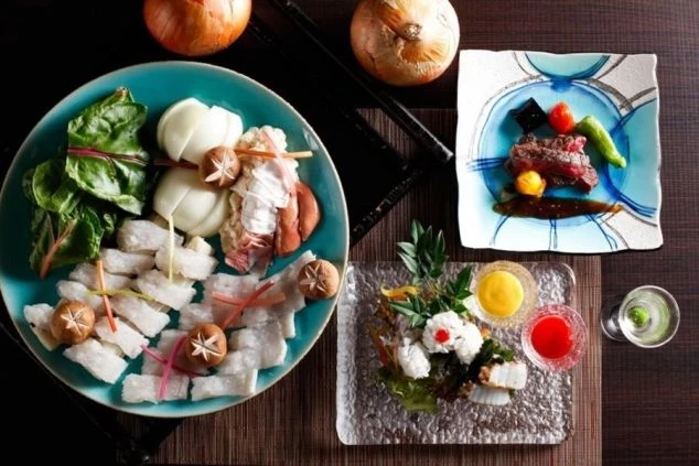 淡路島名物の玉ねぎや牛肉、新鮮な魚介類が美しく盛り付けられた豪華な会席料理。リゾートバイトでまかないが充実していることや、高級旅館での調理補助、レストランサービスに興味がある方に魅力的な画像。