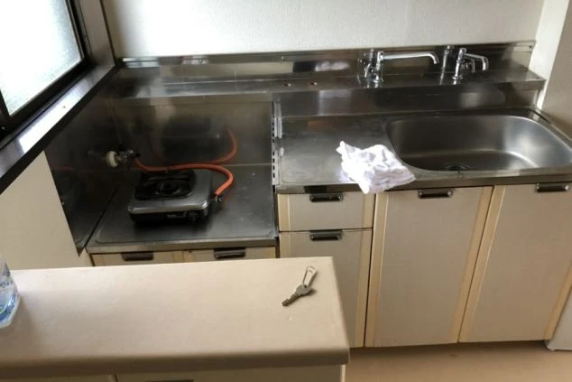 寮のキッチン。シンク、ガスコンロ、調理台が映る共用スペースが映る。