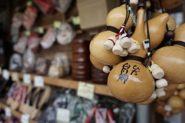 旅館のお土産売り場に吊るされた、ひょうたんに「飛騨」という文字が書かれたキーホルダーの画像。