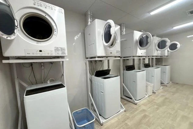 リゾートバイトの従業員寮の部屋の中の、机の上の画像。制服と部屋の鍵、テレビやリモコンが置かれている画像。