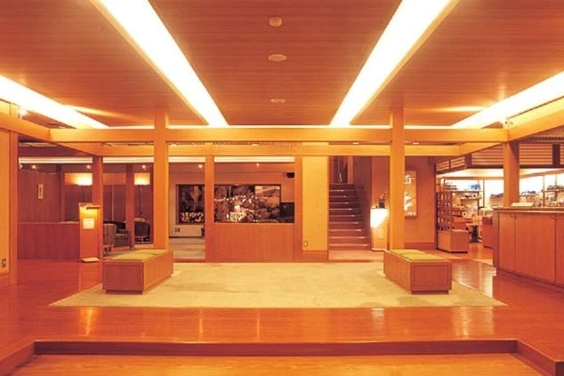 旅館のロビーの画像。木材を基調とした広々とした空間に、ソファーや受付カウンターが写っている画像。