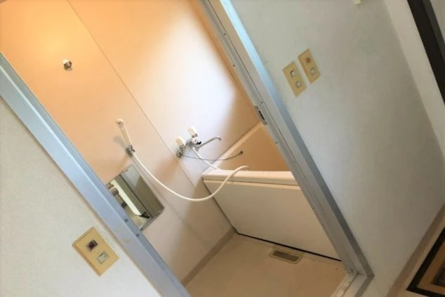 寮のユニットバス。浴槽とシャワー、清潔なタイル壁が映る。