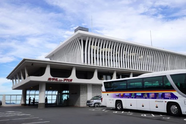 青い海と空を背景に、地形を活かした白い巨大なホテル建築が広がっている。