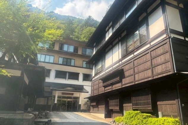 和風建築の温泉旅館の外観。山間に位置し、落ち着いた雰囲気の中でリゾートバイトの仕事に興味がある方に訴求する画像。