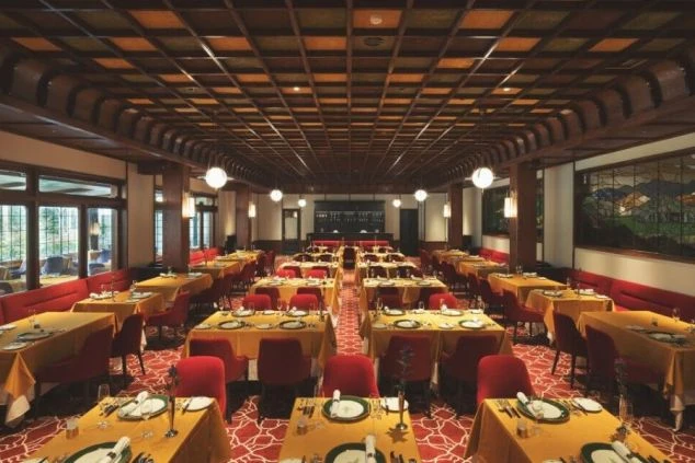 広々とした高級ホテルのレストラン内観の画像。テーブルが整然と並べられている。