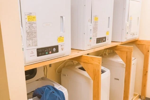 沖縄でリゾートバイトをするスタッフが住む寮の洗濯機と乾燥機の画像。