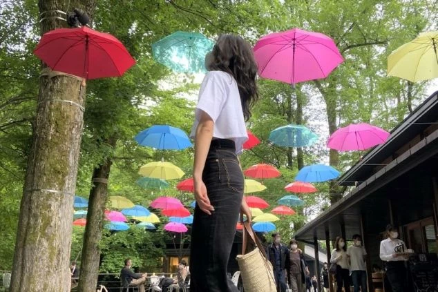 昼間の軽井沢ハルニレテラスに飾られたカラフルなアンブレラスカイの画像。
