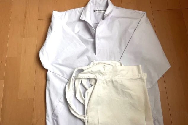 調理補助スタッフ用の制服画像。清潔感のある白のコックコート(白衣)とエプロンのセット。