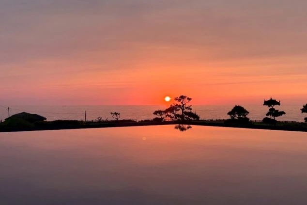 海に沈む夕日。桟橋や船のシルエット。夕焼けの絶景を楽しめるリゾートバイト。