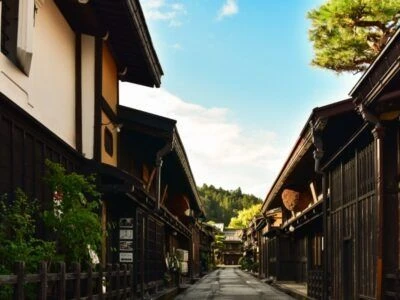 旅館や古民家が立ち並ぶ、日本の情緒ある街並みを写した画像。