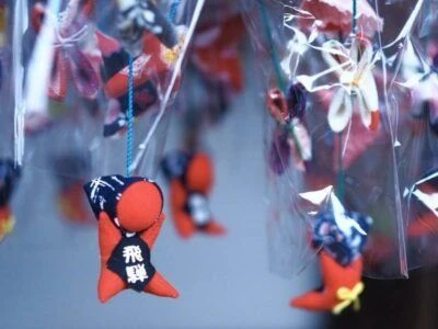 木造の屋根付きの、広々とした旅館の露天風呂の画像。浴槽には温泉が満たされており、周りは木々の緑に囲まれている画像。