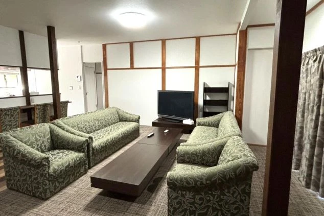 寮のリビング。ソファセット、テレビ、コーヒーテーブルが並び快適。