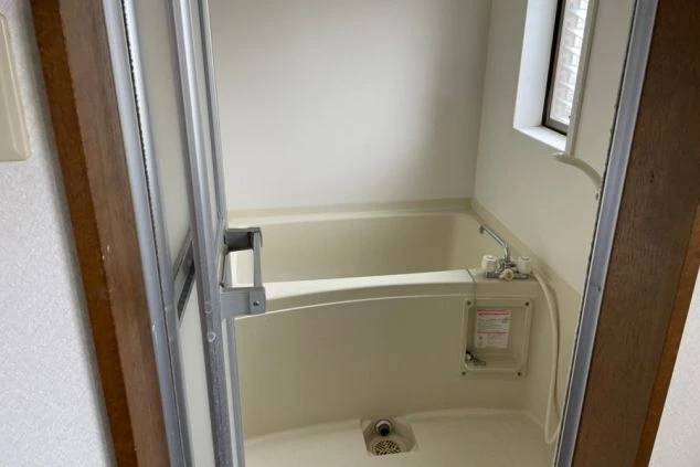 リゾートバイトの個室寮にあるバスルーム。浴槽とシャワーが一体になった、清潔感のある設備の画像。