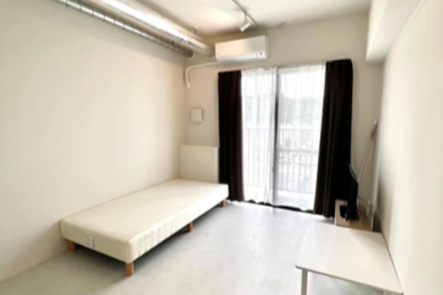 リゾートバイトの個室寮にあるベッドルーム。シンプルで広々とした空間に、ベッドとデスクが備え付けられています。Wi-Fi完備の求人もあります。