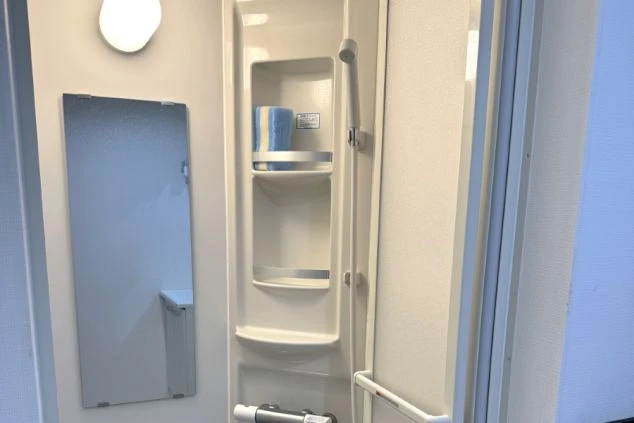 リゾートバイト寮のシャワールーム。大きな鏡と収納棚が備わった清潔な空間で、毎日の身支度もスムーズ。