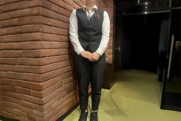 リゾートバイトの仕事風景のイメージ画像。ホテルのフロント業務で着用する、白いシャツと黒いベスト、パンツ。