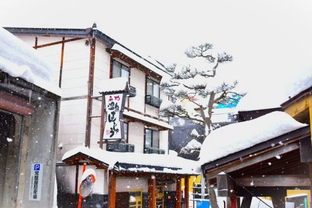 複数の写真がコラージュされており、スノーボードを楽しむ人や、夜の温泉街の様子、楽しそうな若者グループが写っている。「出会いたくさん」「温泉入り放題」「外国人観光客多数」などの文字が書かれている。