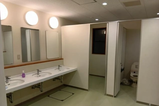 シルバーの冷蔵庫の上に電子レンジが置かれている。