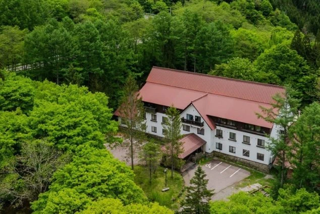 緑豊かな森の中に佇むホテル。自然に囲まれた環境で、お客様に癒しを提供する仕事がイメージできる。