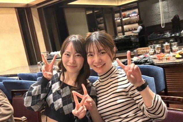 レストランで、楽しそうにピースサインをする二人の女性。