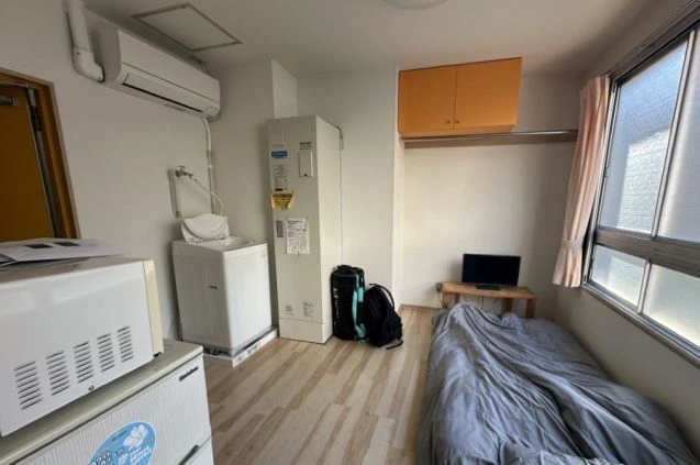 プライベート空間が確保された、リゾートバイトの個室寮の室内。エアコン、洗濯機、冷蔵庫、電子レンジが完備されており、生活に必要な家電が揃っています。
