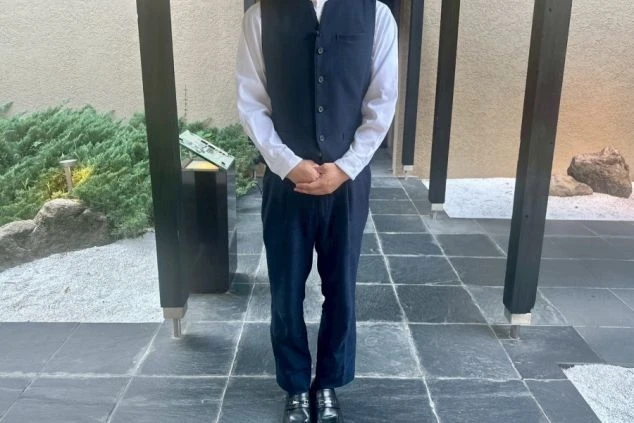 ホテルや旅館の制服。ベストと白いシャツを着用したバトラーが、おもてなしの心で迎える職場のイメージ画像。リゾートバイトの接客業務。