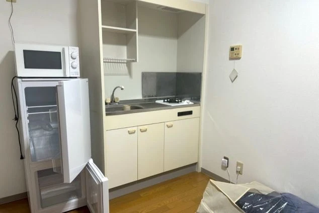 自室で自炊が可能な、ガスコンロとシンク付きのコンパクトなキッチンの画像。