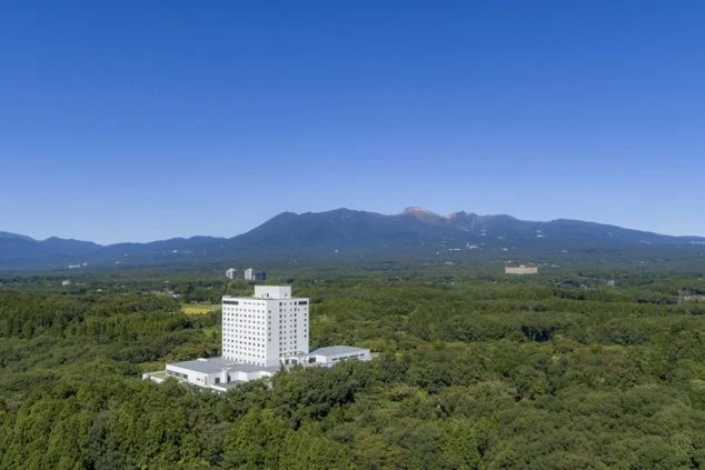 雄大な山々と大自然に囲まれた広大な敷地に建つ大型リゾートホテルの写真。リゾートバイトの勤務地として、非日常的な場所での住み込み生活の魅力を伝えます。