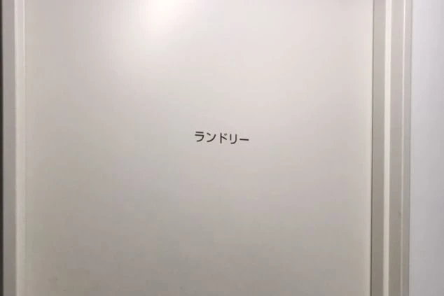 リゾートバイトの館内寮のランドリー室のドア。分かりやすい表示で、寮生活をサポートする設備の画像。
