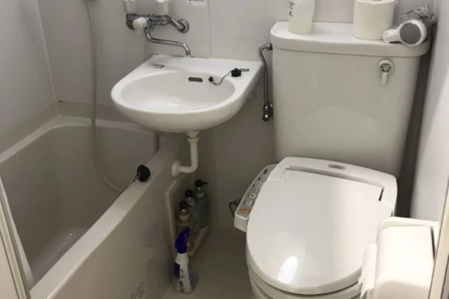 リゾートバイトの館内寮にあるユニットバス。浴槽、洗面台、トイレが一体となった清潔な水回りの画像。