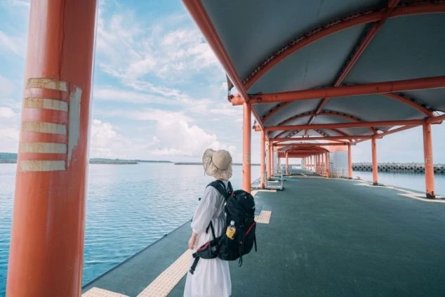 桟橋に立ち海と空が広がる景色を眺める旅人の後ろ姿。リゾートバイトで、新しい土地での一人旅や非日常を体験できる魅力を伝えます。
