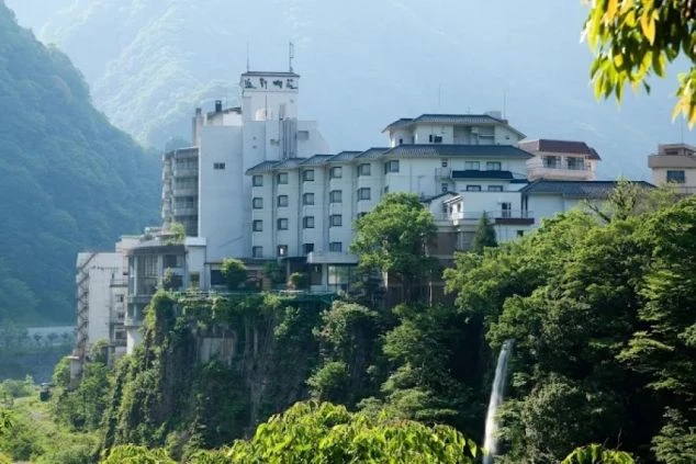 渓谷に建つ旅館の外観。自然に囲まれた環境で、お客様に癒しを提供する仕事がイメージできる。