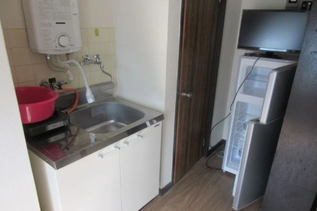 リゾートバイトの個室寮に完備されたミニキッチンと冷蔵庫。自炊も可能で、コンビニやスーパーも徒歩10分圏内の宇奈月温泉で生活しやすい環境です。