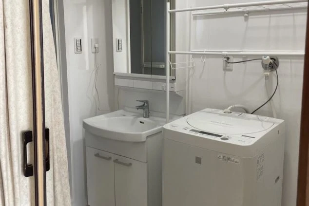 石垣島でリゾートバイトするスタッフが住む寮の洗面台と洗濯機の画像。