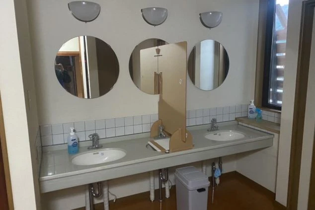 リゾートバイトの男子寮にある共用の洗面所。複数の洗面台と鏡があり、パーテーションで区切られているので、気兼ねなく利用できます。