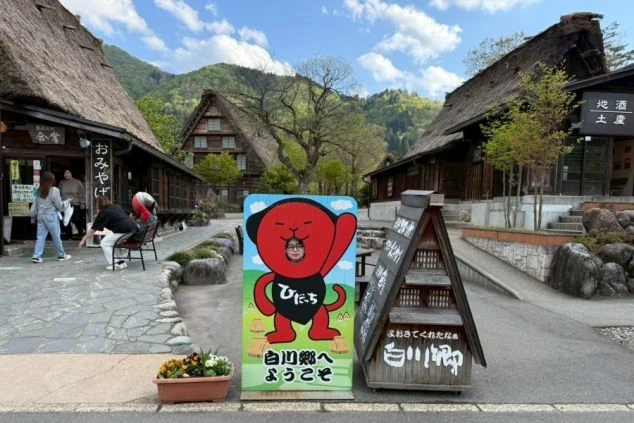 合掌造り風の屋根が特徴的な、風情ある岐阜県白川郷エリアの温泉旅館の玄関アプローチの画像。