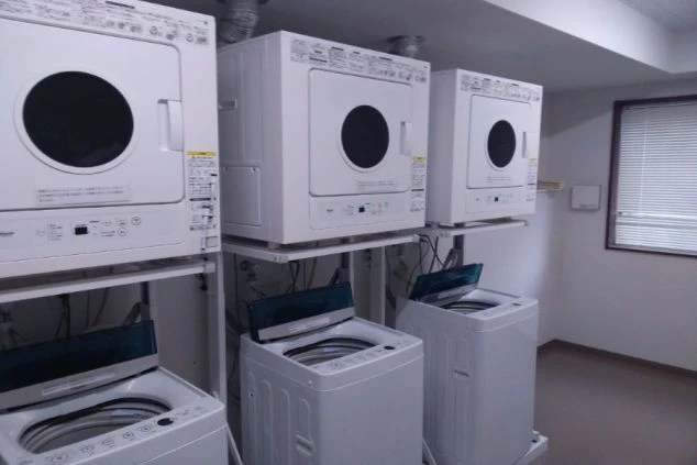 リゾートバイトの女性寮にある、共用のランドリールーム。洗濯機と乾燥機が複数台設置されているので、いつでも洗濯できて安心です。