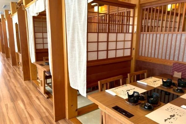 合掌造り風の屋根が特徴的な、風情ある岐阜県白川郷エリアの温泉旅館の玄関アプローチの画像。