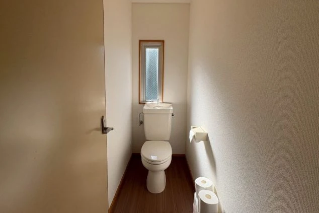 寮内の独立したトイレの画像。温水洗浄便座(ウォシュレット)完備で、プライバシーと清潔感を重視した居住設備。