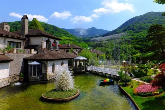 リゾートバイトの休日に観光するイメージ画像。神奈川県箱根にある「箱根ガラスの森美術館」の、ヴェネチアングラスで装飾された庭園と建物、水路の美しい風景。