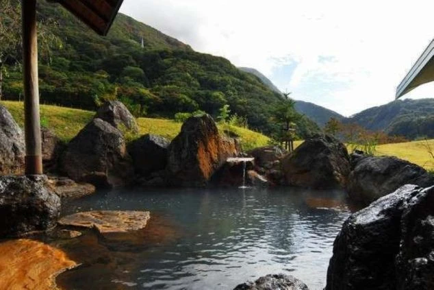 自然に囲まれた山あいにあり、複数の大きな岩に囲まれた露天風呂。