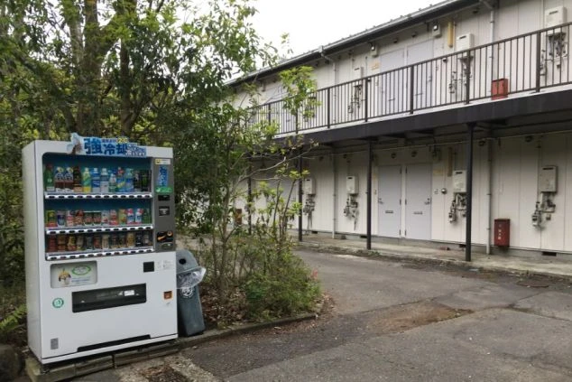 リゾートバイト寮の外観。2階建てのアパートタイプで、玄関前には自動販売機がある。