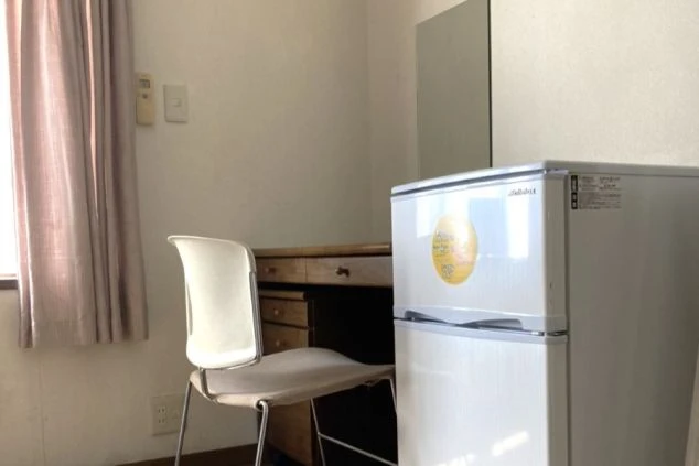 岐阜県下呂温泉でリゾートバイトをするスタッフが住み込む寮の画像。デスク、チェア、冷蔵庫が完備されている。