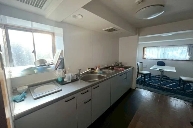 リゾートバイト個室寮のキッチン。IHコンロ完備で自炊も可能。奥には食事ができるスペースもあり便利な環境。