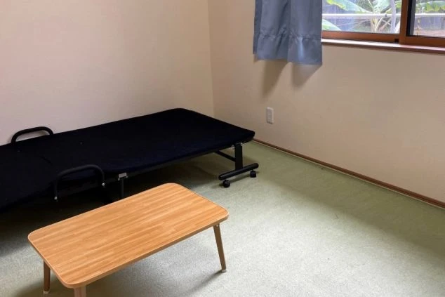 ワクトリの社員が出張で撮影した、リゾートバイトの寮の一室の画像。シンプルな和室に折りたたみベッドとローテーブルが置かれ、窓からは光が差し込む。リゾートバイト中の生活の拠点となる部屋の様子。