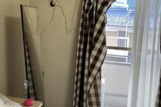 チェック柄のカーテンと姿見が置かれた、落ち着いた雰囲気の部屋。リゾートバイト中の生活も快適に過ごせます。