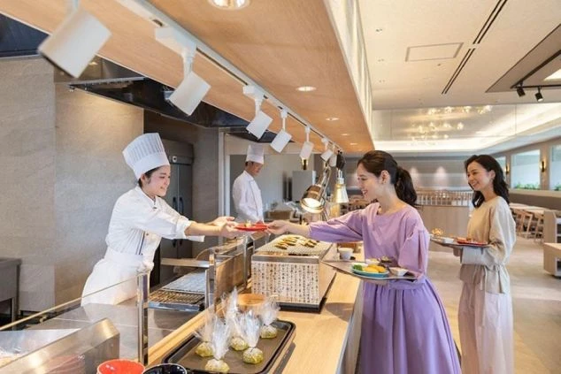 笑顔で料理を受け取るお客様。お客様との距離が近いレストランで、心のこもったおもてなしを体験できます。