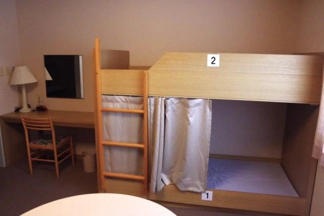 リゾートバイトの寮に完備された相部屋。二段ベッドにはカーテンがあり、プライバシーを守りながら共同生活ができる。
