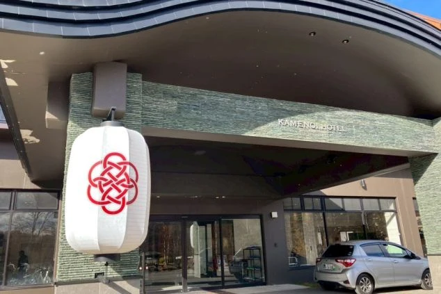 エントランス。大きな湾曲した黒い庇が特徴的で、左右に紋章入りの白い提灯が飾られている。